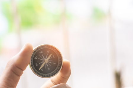 holding compass on blurred background. Using wallpaper or background travel or navigator image.の写真素材