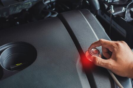 Asian man holding stethoscope car inspection Rubber tires car.Close up hand holding stethoscope for car tyre pressure measurement for automotive, automobile imageの写真素材