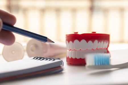Close up Denture with toothpaste Toothbrush on blurred background. Metaphor for oral, dentures jaw toothy healthcare protect.の写真素材
