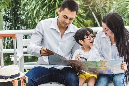 father mother and the son hold passport, map to trip family Preparing for traveling We are Poses selfie Before travel for trip travel abroad lifestyle happy life with family.の写真素材