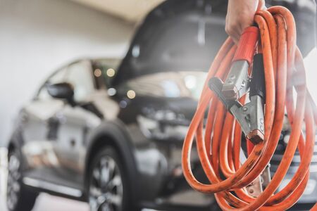 Man inspection holding jumper cables for charger Battery service maintenance of 
industrial to...