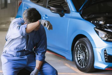 Asian man car inspection Measure quantity Inflated Rubber tires car.Closeup hand holding tire and blue car for tyre pressure measurement for automotive, automobile Car industry imageの写真素材