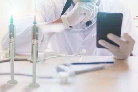 man scientist Chemical research working in lab inject with Hold smartphone scanning Covid 19 for stop covid 19 virus covid-19 or corona protected Help protect For stop virusの写真素材