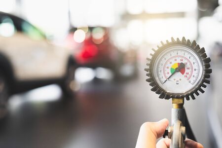 inspection Measure quantity Inflated Rubber tires car Close up hand holding machine Inflated pressure gauge for car tyre pressure measurement for automotive automobileの写真素材