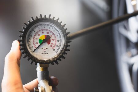 inspection Measure quantity Inflated Rubber tires car Close up hand holding machine Inflated pressure gauge for car tyre pressure measurement for automotive automobileの写真素材