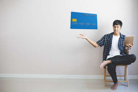 Man working on sofa in home hold smartphone with credit card for dollar shopping online.you enjoy...