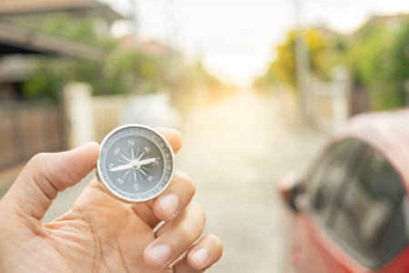 Man hand holding compass on city and car blurred background Using wallpaper or background travel or navigator image.の写真素材