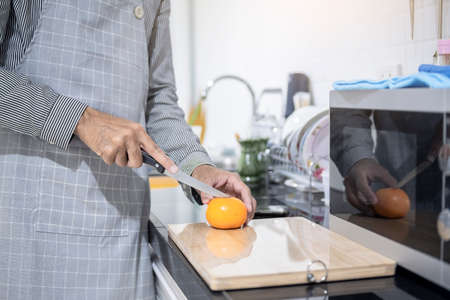 Blurred man asian cooking in kitchen of home He hands cutting vegetables and cutting fruit in the...