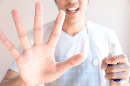 Asian male inspector smile to cleaning staff in bathroom disinfectant sprayers and germs Metaphor for cleaning Get rid of germs In bathroom, home office For reliability And satisfaction serviceの写真素材