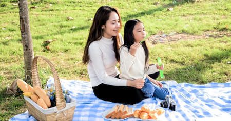 Asian portrait family trip father mother and daughter enjoy relaxation Blowing bubbles with family to lifestyle freedom family vacation caucasian asian.one day trip new normol togethernessの写真素材