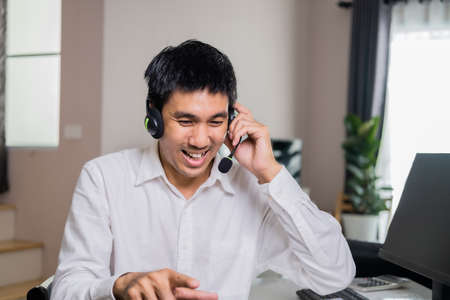 Asian male hand writing order product list on note for online customer in warehouse home office ordering products from online to business cargo supply market service  delivery form home office.の写真素材