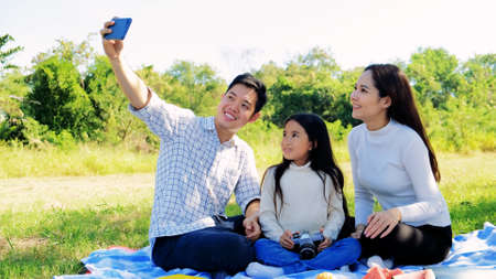 Asian portrait family trip father mother and daughter enjoy relaxation playing selfie with family to lifestyle freedom family vacationの写真素材