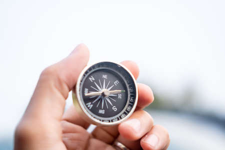 Man hand holding compass on city and car blurred background Using wallpaper or background travel or navigator image.の写真素材