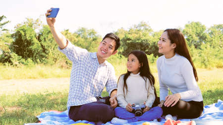 Asian caucasian family taking selfie with parents father mother daughter in  vacation to smiles in gerden so joyful feeling with family of holiday togetherness joy relationship lifestyle asians peopleの写真素材