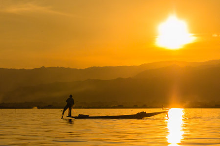 Fisherman with Leg rowing during Sunset,  inle lake in Myanmar  Burmar の写真素材