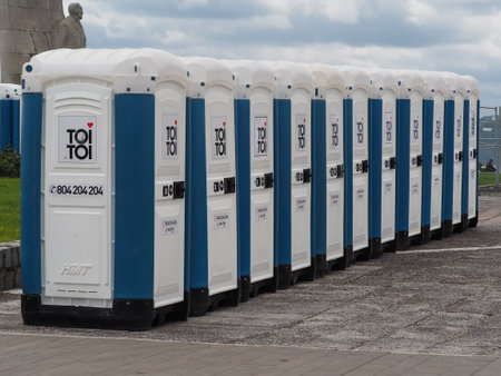 Gdynia Poland-June 30, 2014 - Portable white and blue toilet cabs set up in a row before a public outdoor partyのeditorial素材