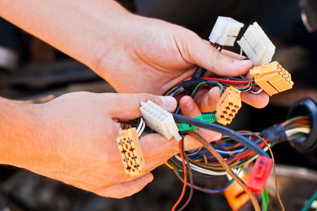 Young electrician man holds the wires