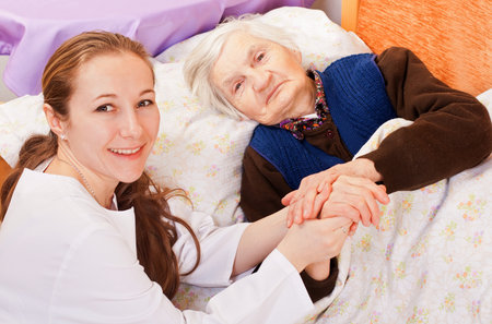 Young doctor holds the old woman's handsの写真素材