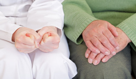 Clasped anxious young and elderly relaxed handsの写真素材