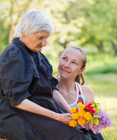 Elderly woman get flowers from her grandchildの写真素材