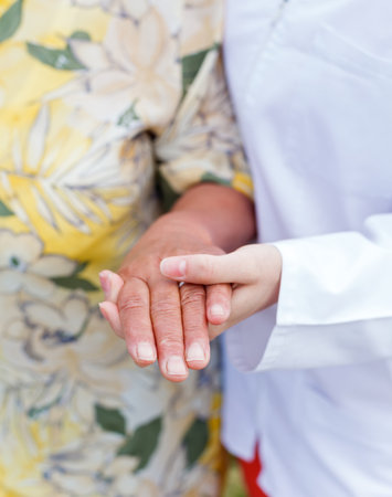 Young doctor holds the elderly woman handsの写真素材