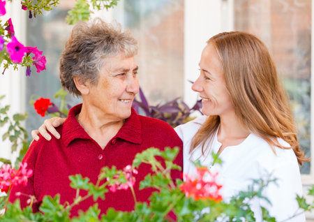 Happy elderly woman and her helpful assistantの写真素材