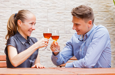 Happy couple drinking rose wine  in a restaurantの写真素材