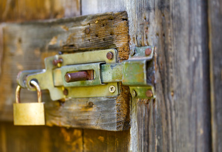 Rusty old sliding block latch with padlockの写真素材