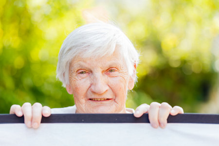 Portrait of the smiling elderly woman on outdoors