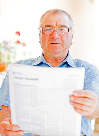 Elderly man read newspaper on the verandaの写真素材