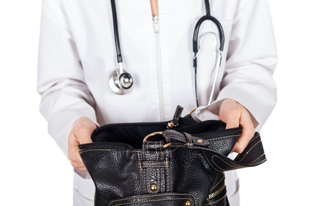 Young doctor looking for credit card in her bagの写真素材