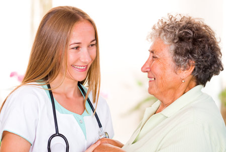 Photo of happy elderly woman with the young doctorの写真素材