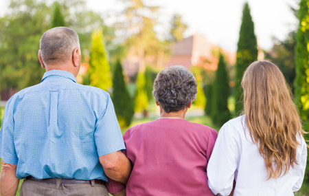 Elderly couple walking in the nature with the carerの写真素材