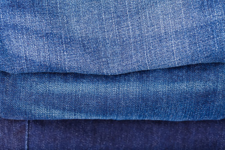 Close up photo of different colored blue jeansの写真素材