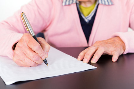 Photo of elderly woman who is writing a letterの写真素材