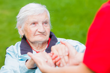 Young carer giving helping hands for elderly womanの写真素材