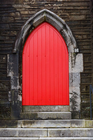 Photo of a red gothic arched church doorの写真素材
