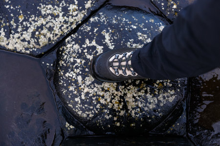 Close up photo of a tourist hiking boots at Giants Causeway in Irelandの写真素材