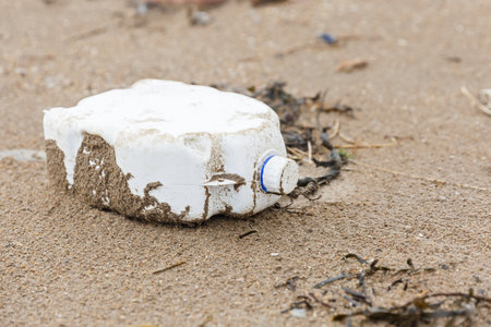 Close up photo of a plastic bottle litter on the beachの写真素材