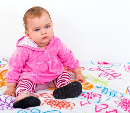 Photo of an adorable baby sitting on the bedの写真素材