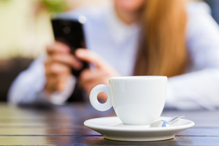 Young woman texting a message in coffee breakの写真素材