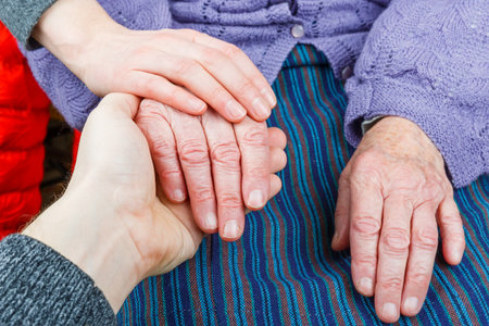 Young carer giving helping hands for elderly womanの写真素材