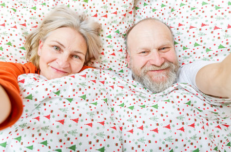 Happy senior couple resting in the bed