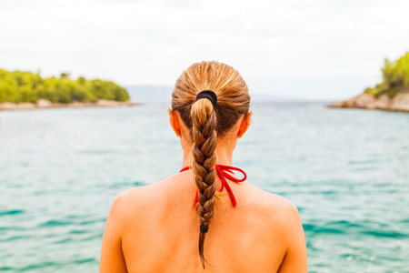 Young woman sitting and meditating on the beach