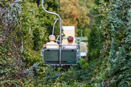 Photo of elderly women on chairlift in the mountainsの写真素材