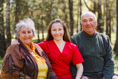 Portrait photo of elderly couple and young caregiver