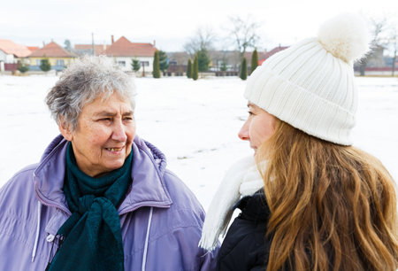 Photo of happy elderly woman and young caregiver