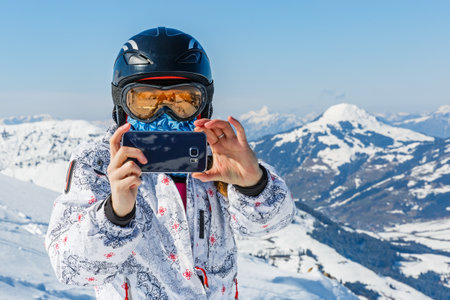 Young skier woman taking photo with the smartphoneの写真素材