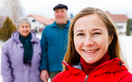 Photo of happy young caregiver and elderly couple