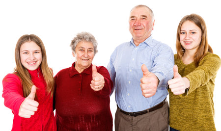 Photo of happy grandparents and granddaughters showing thumbs up
